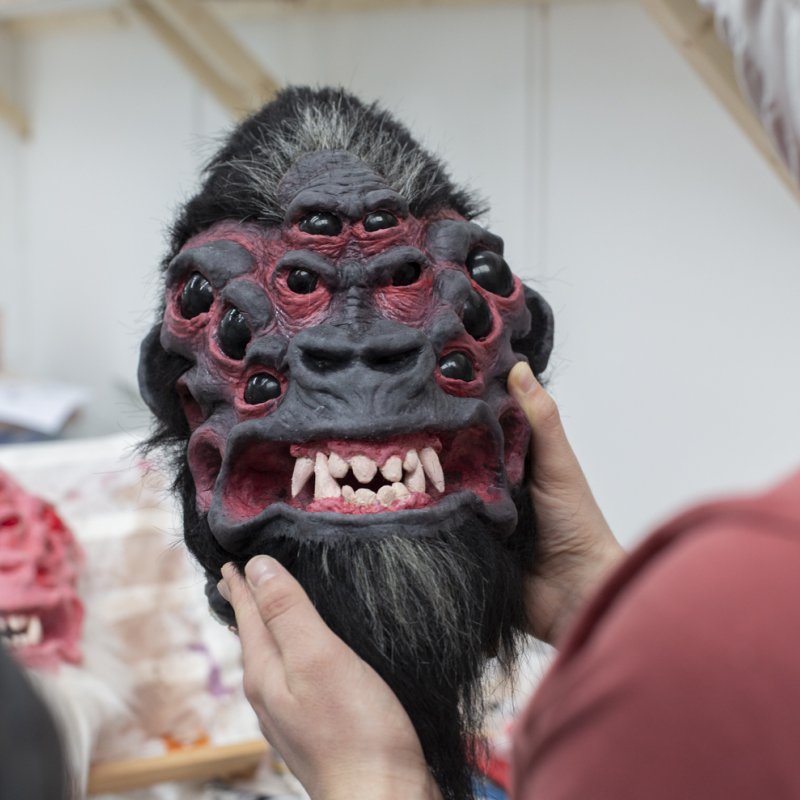 A model of a gorilla's head with multiple eyes