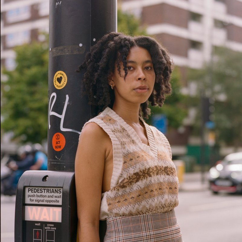 Woman poses by sidewalk