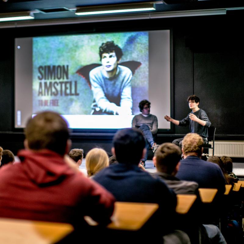 Simon Amstell in discussion on stage in lecture theatre at Falmouth University