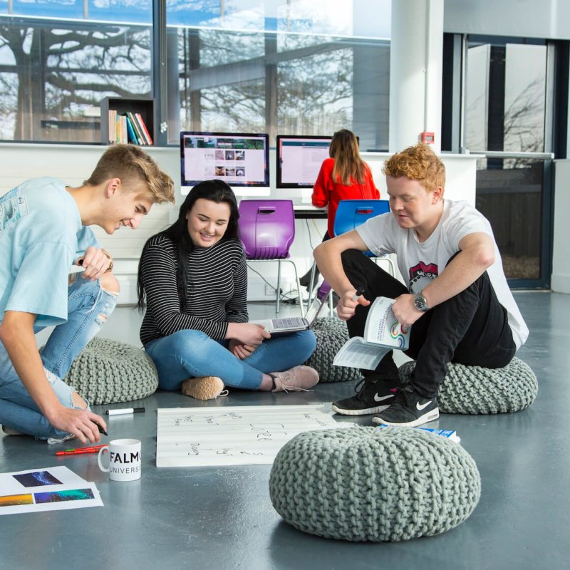 Falmouth University Business students sat on pebble cushions discussing ideas.