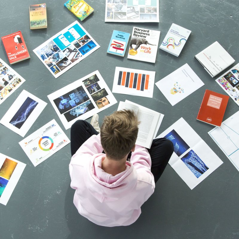 A Falmouth University student sat on the floor surrounded by papers and books
