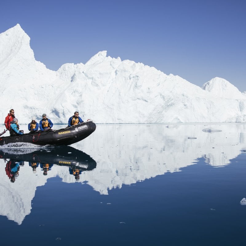 Group on boat next to iceberg