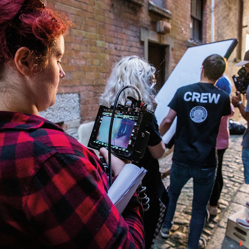 A group of Television students on a television production set with a camera