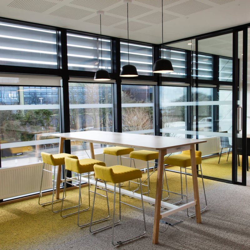 Yellow stools inside the Creative Bridge building on Penryn Campus