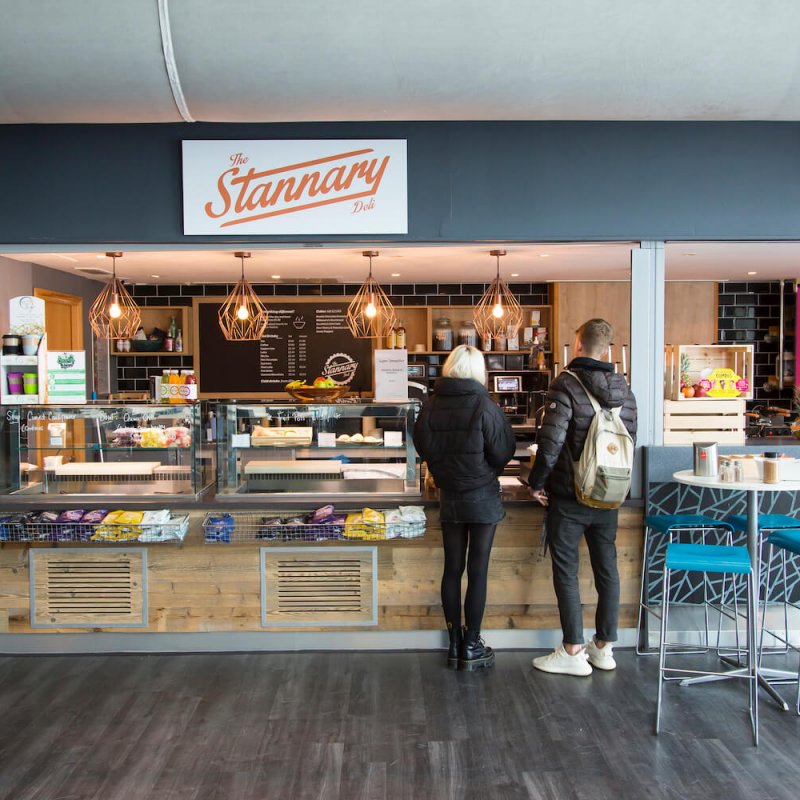 Two students standing at the Stannary bar on Penryn Campus