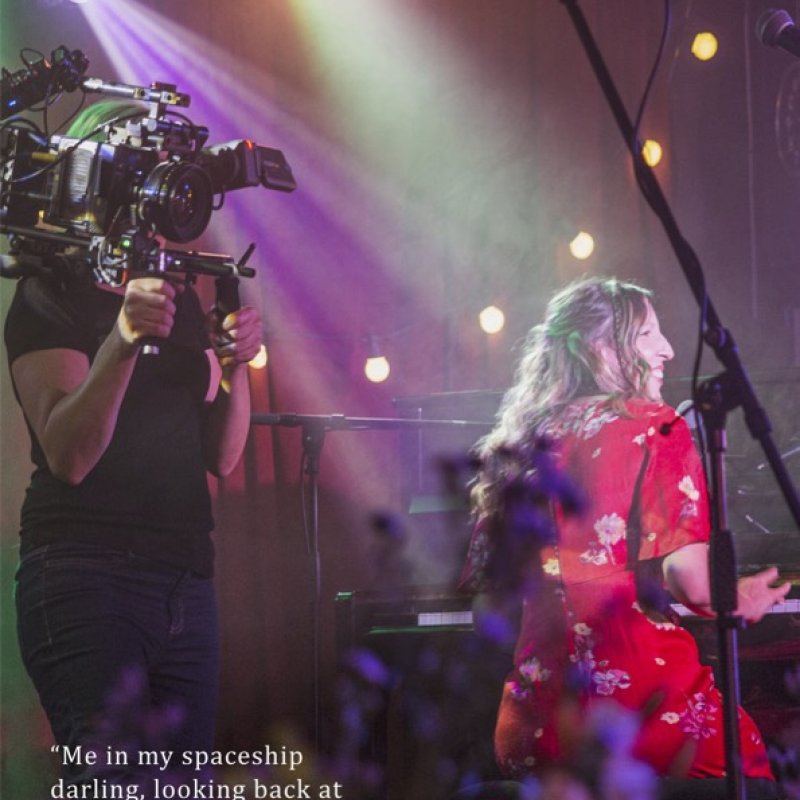 A woman is being filmed playing the piano