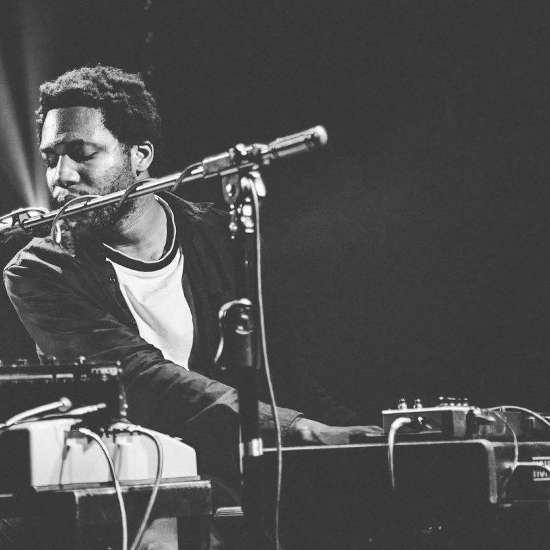 Falmouth student singing into microphone and playing keyboard.