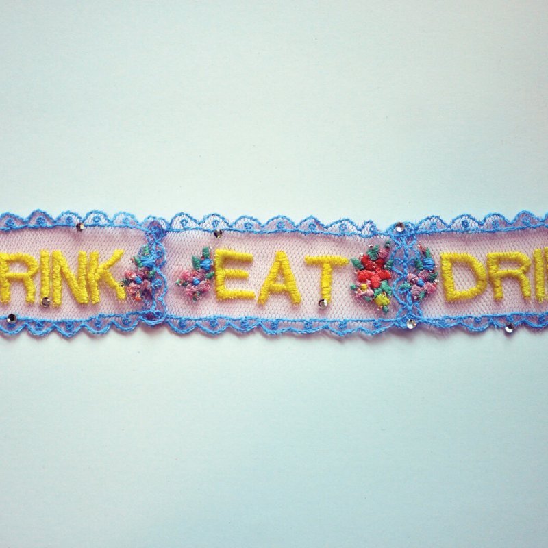 Lace trimming embroidered with flowers and the words eat and drink.