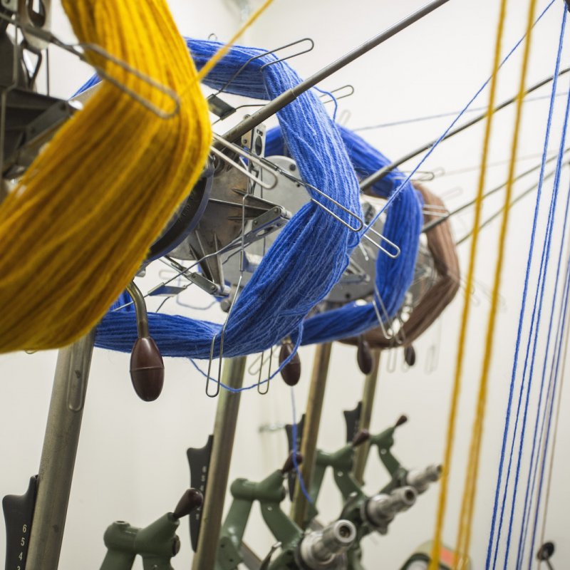 Yellow and blue wool on a loom machine