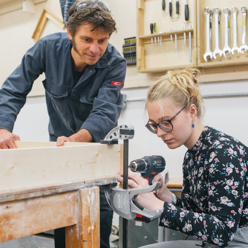 Female student and technician working in a workshop