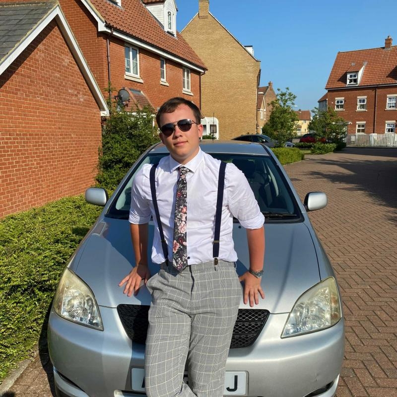 James poses on his car wearing aviators and