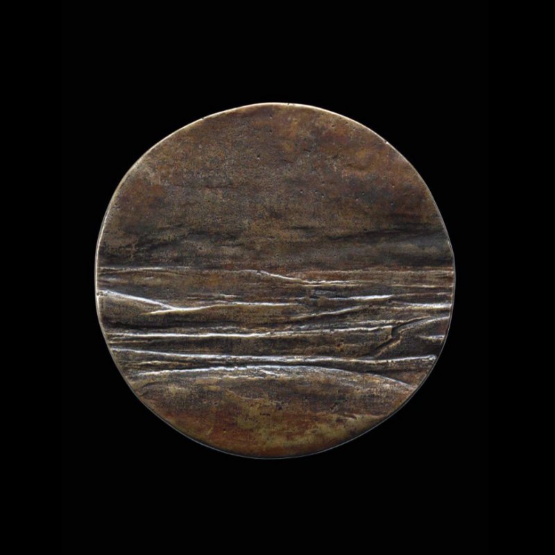 Circle made from sandstone of landscape set on a black background.