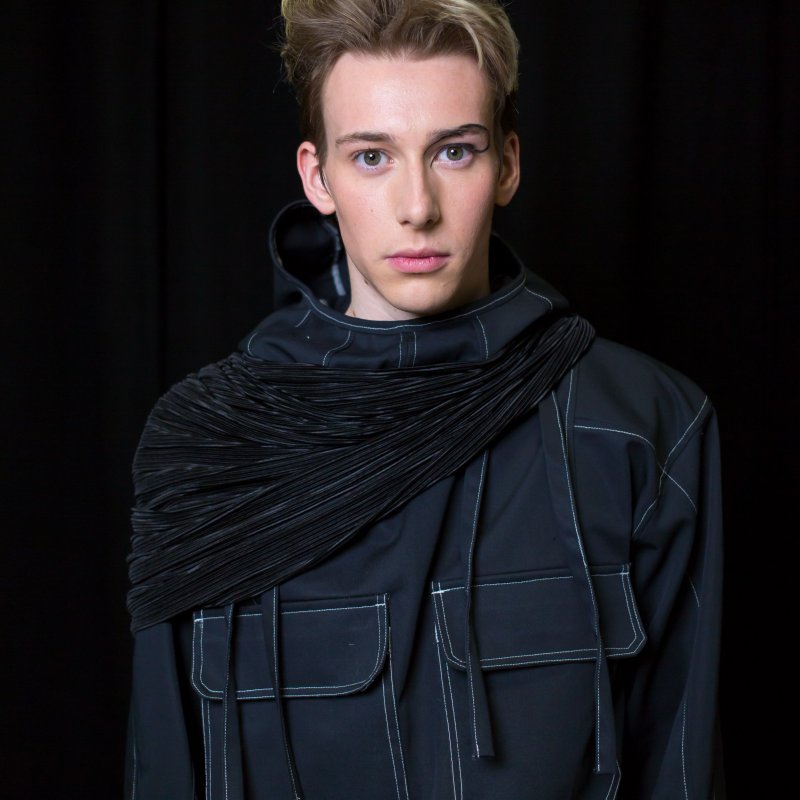 Student portrait - a white man with blonde hair wears a black top