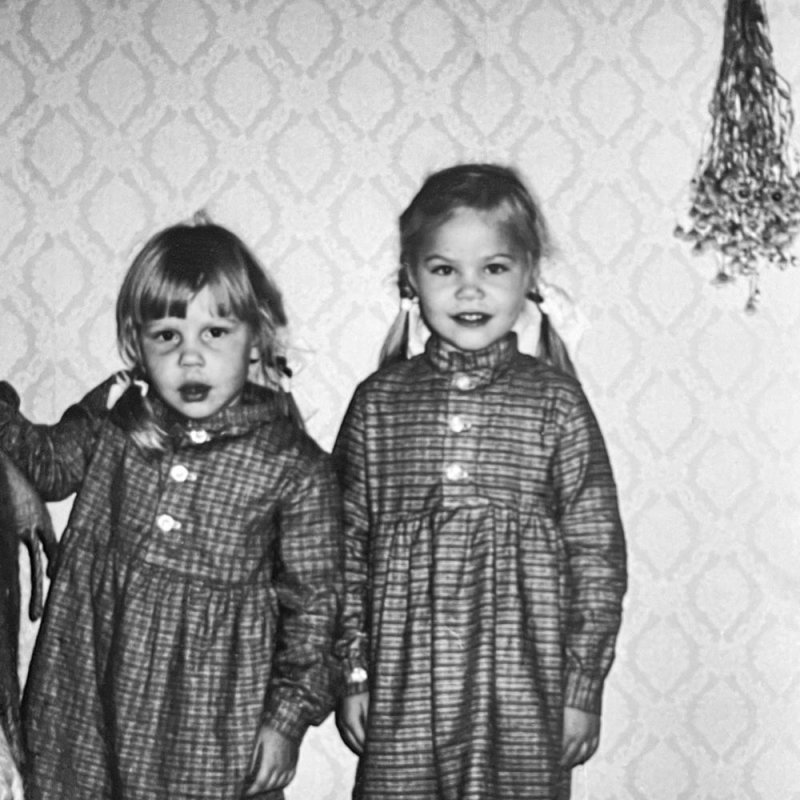 Black and white photo of two girls in matching dresses