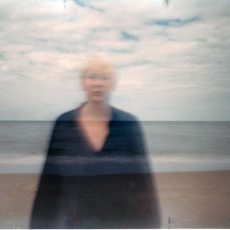 A blurred photo of a woman on a beach