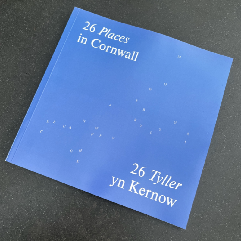 Photo of 26 Cornwall book - light blue cover with A-Z of letters scattered in the shape of Cornwall  in white. Title reads: 26 places Cornwall / 26 Tyller yn Kernow