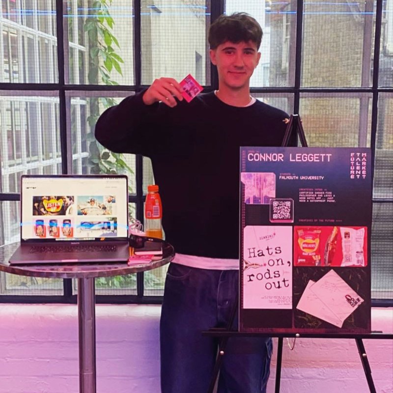 A man stood by a table with his creative work