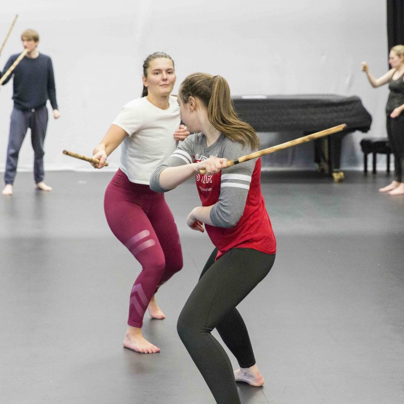 Acting students in combat workshop working with wooden sticks