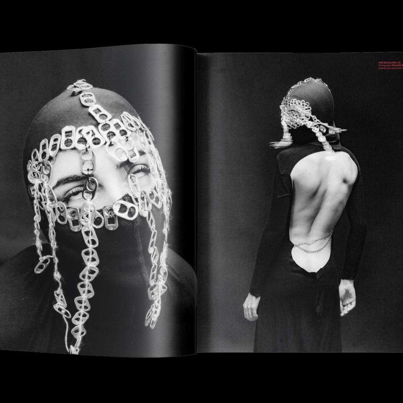A magazine double page spread featuring a model in a chainmail headdress and black dress
