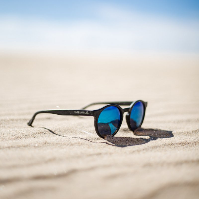 A pair of sunglasses on the beach