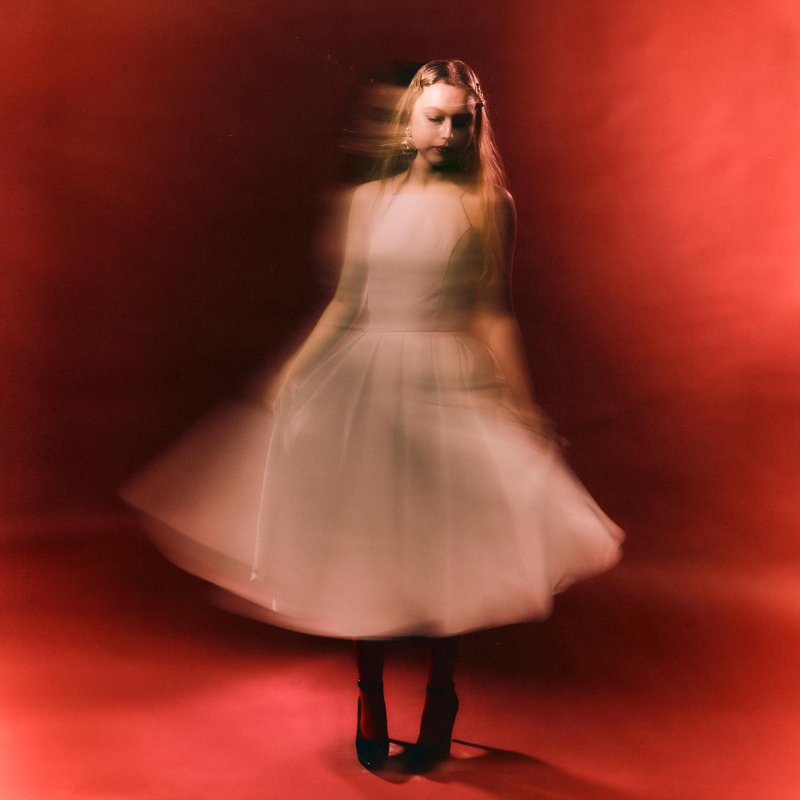 Photograph of a model in a pink dress with red background