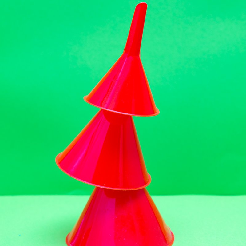 Three red cones stacked against a green background