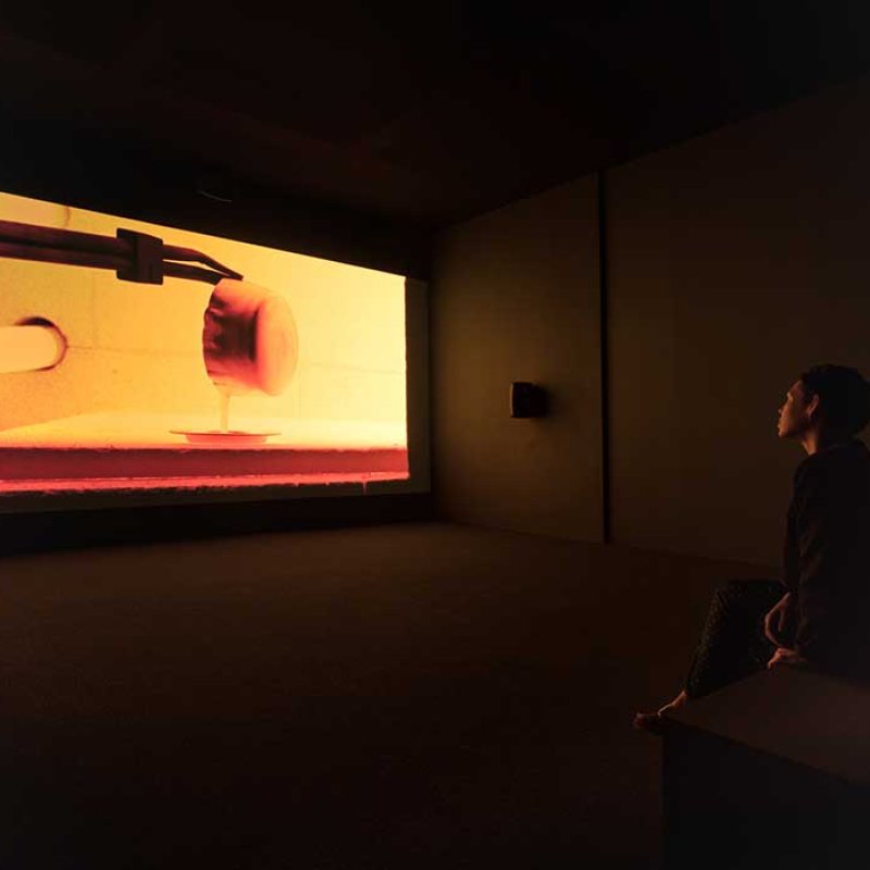A dark gallery showing a film by artist Steve McQueen 