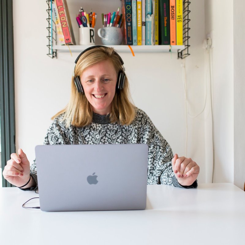A woman smiling while looking at her laptop