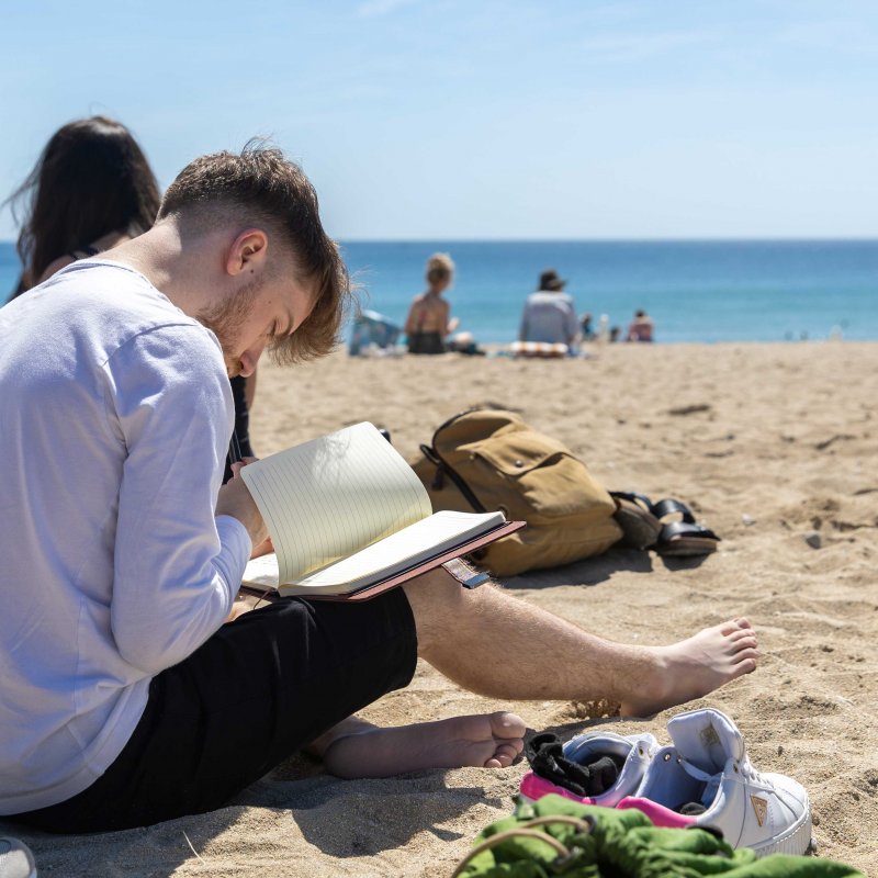 BA Creative Writing (Online) student working on the beach 