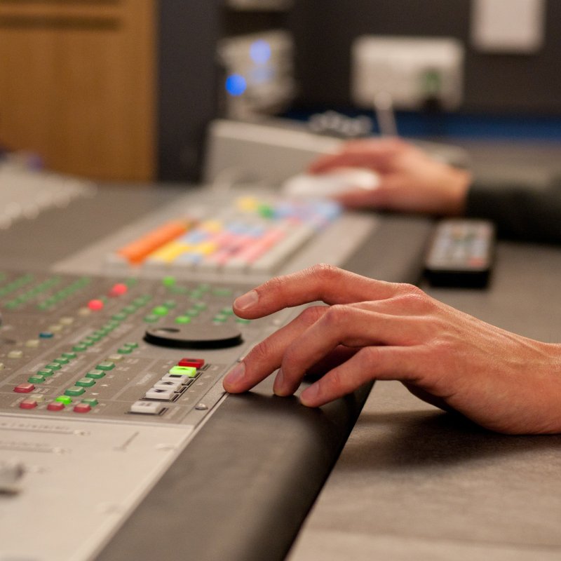Close up of person's hands operating sound controls in Falmouth University studio
