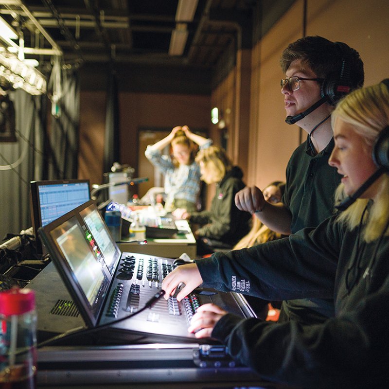 Two people sitting at a theatre tech desk working