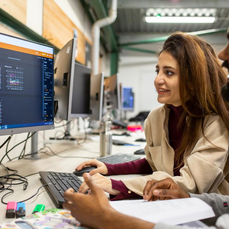 Two AI for Games students at a computer at Falmouth University
