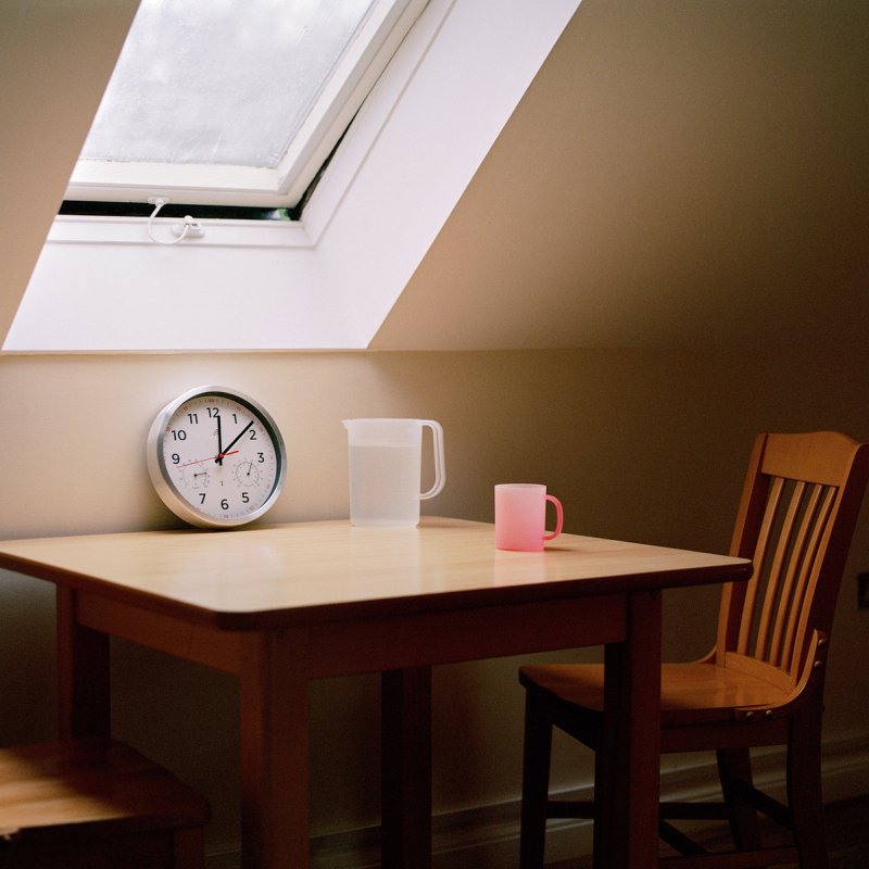 Table and chairs beneath a skylight window.