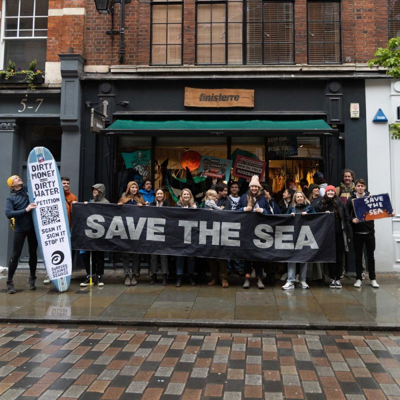 A group of people with 'Save the Sea' banner outside Finisterre shop