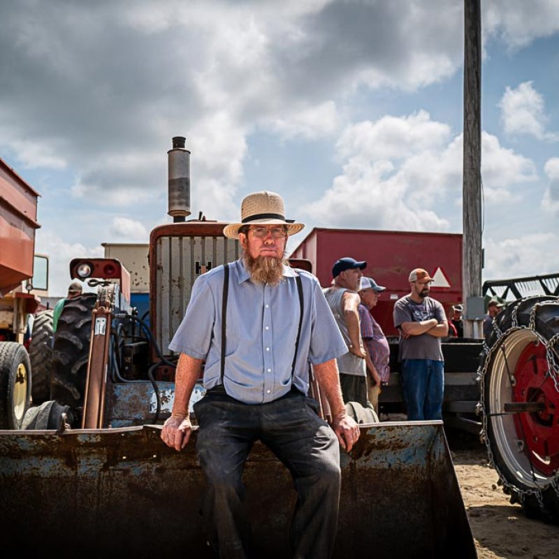 A man sitting on the front of a tractor