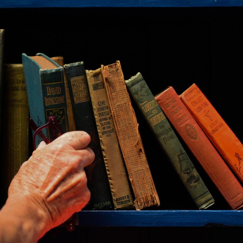 A hand taking a book from a shelf
