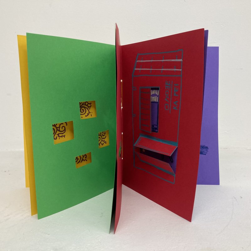 Inside of a colourful paged book with cut out designs