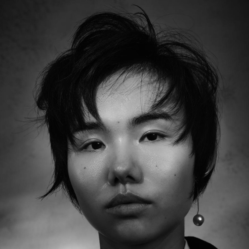 Photograph of a woman with cropped black hair and earings