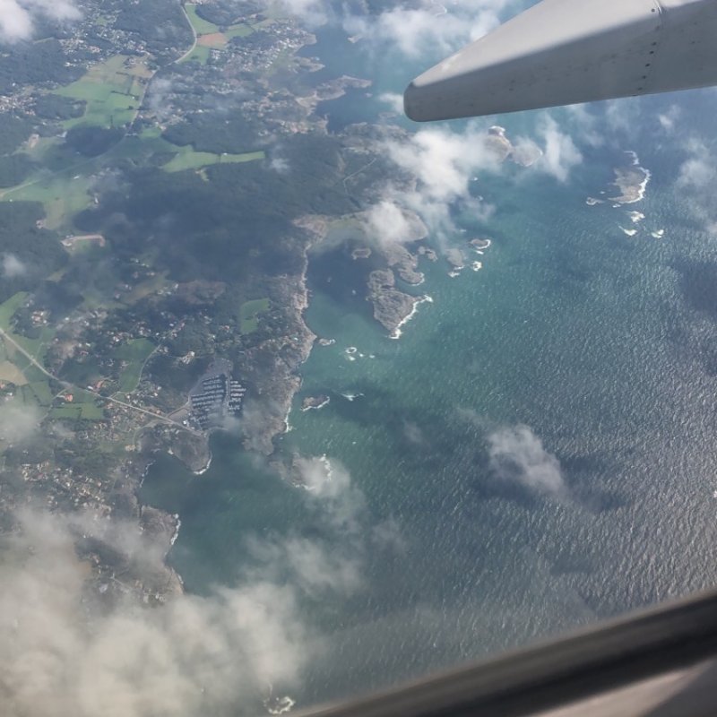 view of land and sea out of an airplane window.