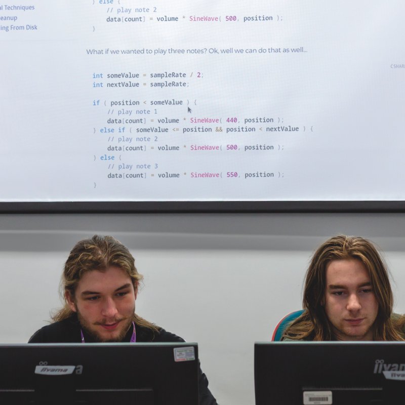 Computer Science students working at whiteboard and computers