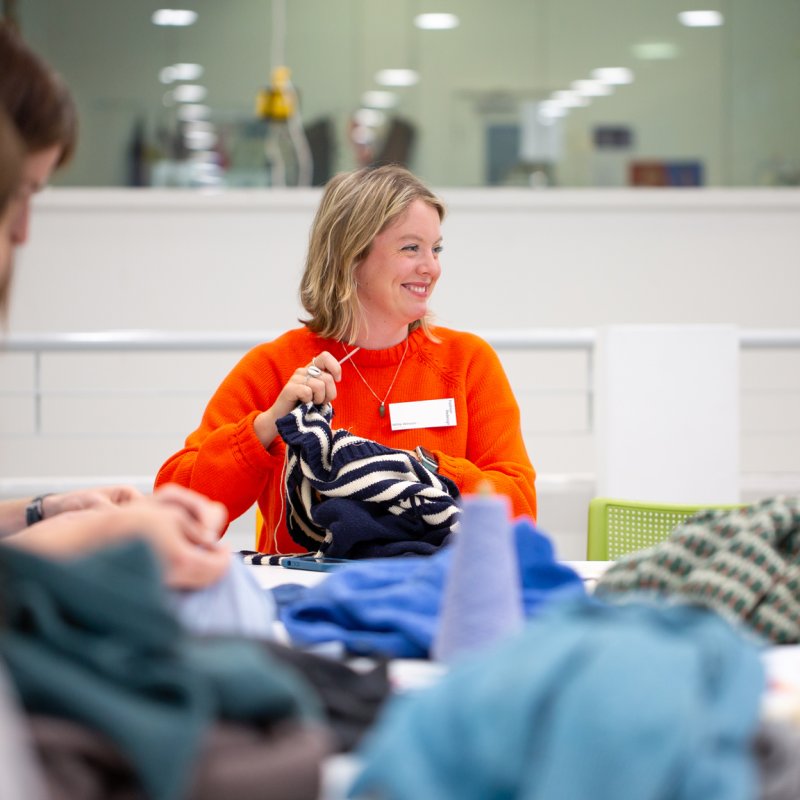 A woman leading a garment mending workshop