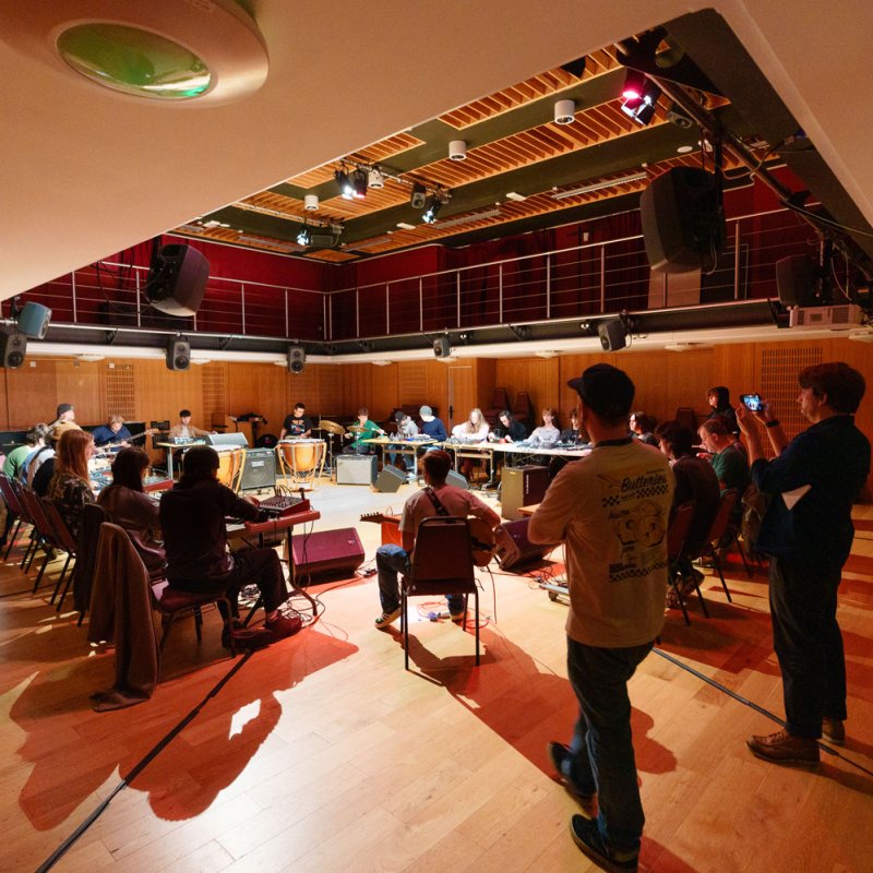 Creative Music Technology students sitting around tables in a large studio