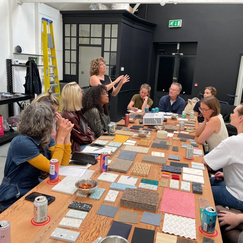A workshop with people sat around a table looking at different materials