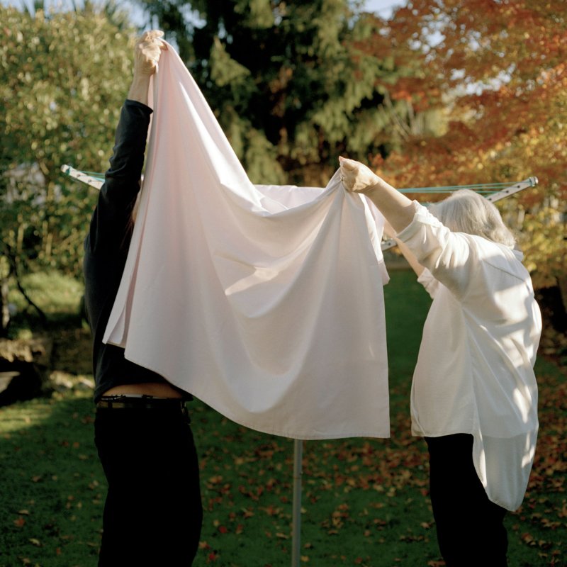 Photography: two people wearing balck and white hanging out laundry