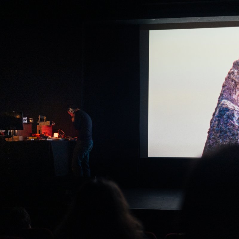 Two men on a stage using analogue equipment to perform a live film score