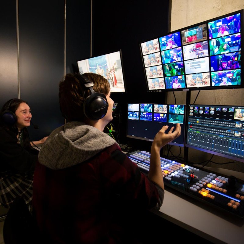 Two Falmouth University students working in an Esports studio with multiple screens