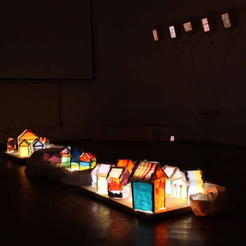 Beach huts lit up at night