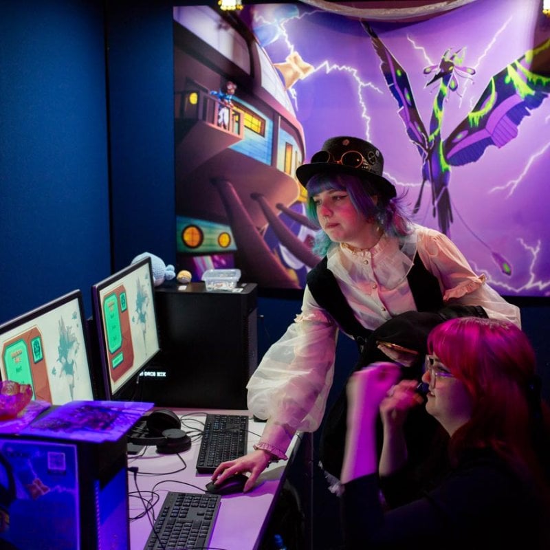 Two Falmouth University students playing a game at the Games Expo