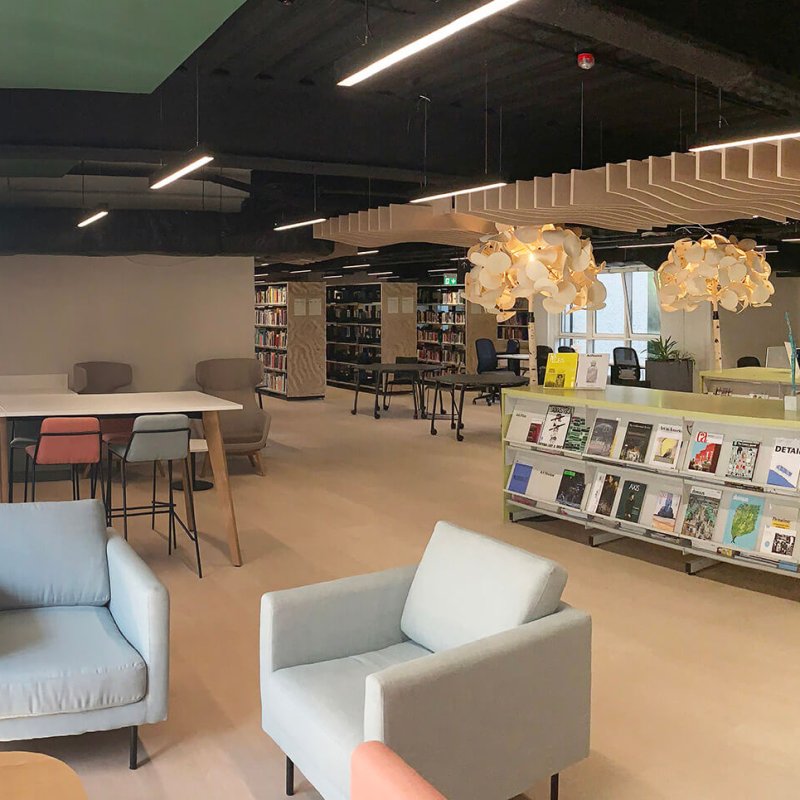 View of Falmouth University library with blue chairs and bookcases