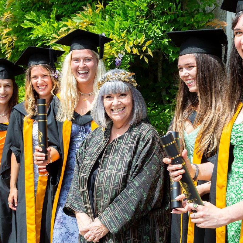 Chancellor Dawn French with female students at Falmouth University graduation ceremony
